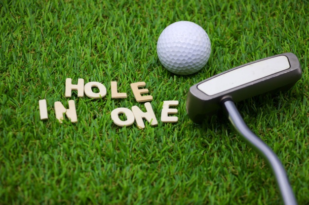 a golf ball and club that says, "hole in one"
